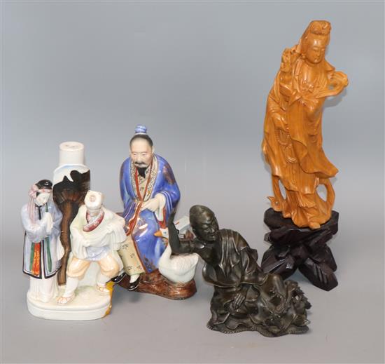 A Chinese wood carving, two Chinese porcelain figures and a bronze